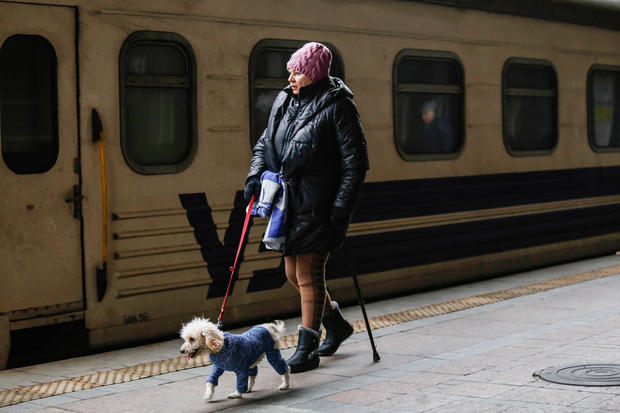 A woman is seen with her dog at the railway station in Kyiv 
