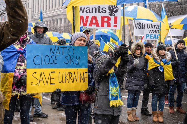 A protester holds a placard in colors of the Ukrainian flag 