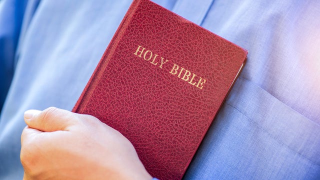 Human hand placed on the Bible, pray to God. 