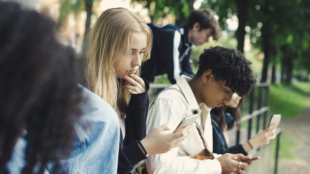 Teens using social media on their mobile phones 