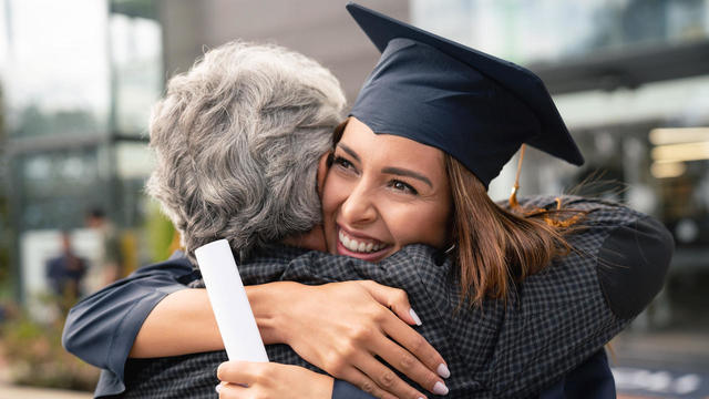 Happy student hugging her father at graduation 