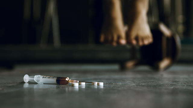 Syringe and drugs with out of focus The foot of the person commit suicide.Depression.International Day against Drug Abuse and Illicit Trafficking 