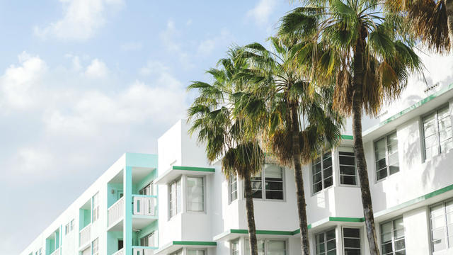 Art deco buildings and palm trees against sky during sunny day, Florida, USA 