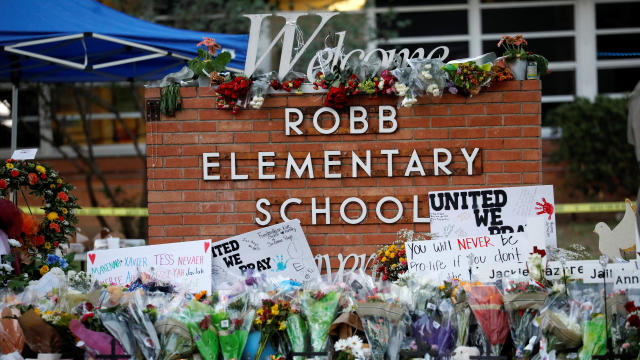 Flowers, candles and signs are left at a memorial for victims of the Robb Elementary School shooting, three days after a gunman killed nineteen children and two teachers, in Uvalde, Texas, May 27, 2022. 