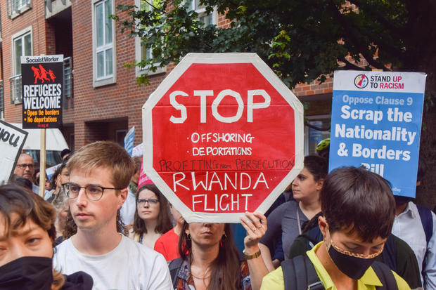 A protester holds a 'Stop Rwanda flight' placard during the 