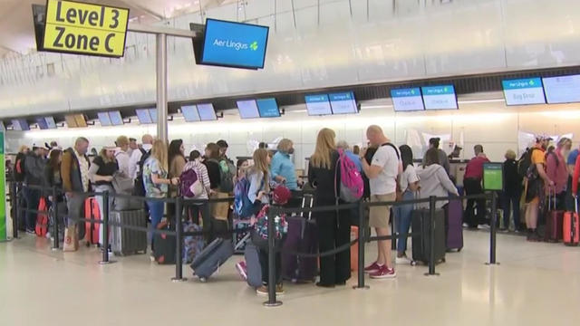 Travelers wait in line at Newark Liberty International Airport. 