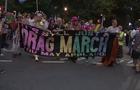 Participants march down the street carrying a banner that says "It's still just a Drag March, you may applaud" 