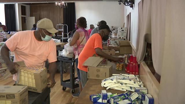 Volunteers inside the Willing Heart Community Care Center in Newark unpack food to be given away. 