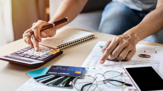 Midsection Of Woman Analyzing Financial Bills 