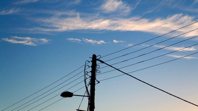 Street light and cables in Lower Radley Village, Oxfordshire, illuminated by the rising sun s5 