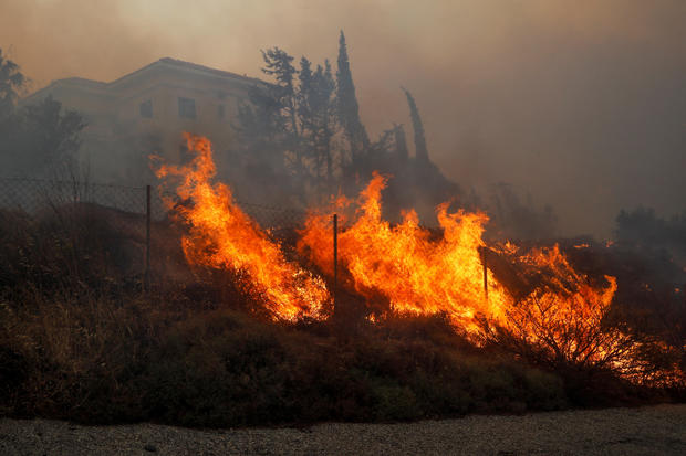 A wildfire burns near a house in Ntrafi, Athens 