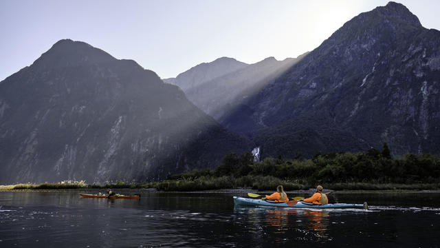 Tourists kayaking in the waters of the Milford Sound when 