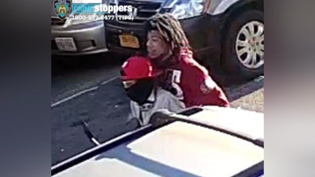 Surveillance photo of two individuals on a moped. 