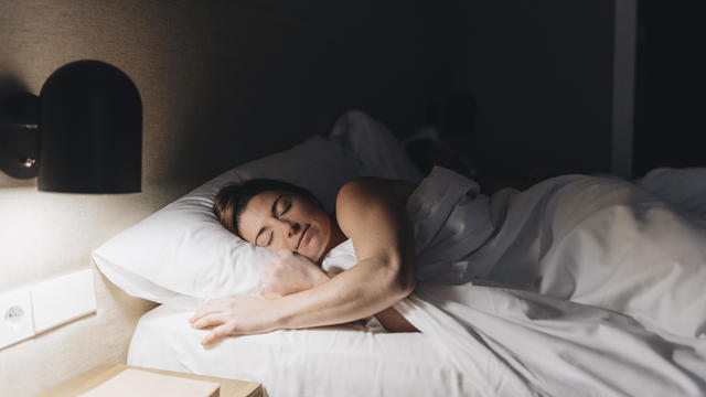 Beautiful woman sleeping on bed in hotel room 