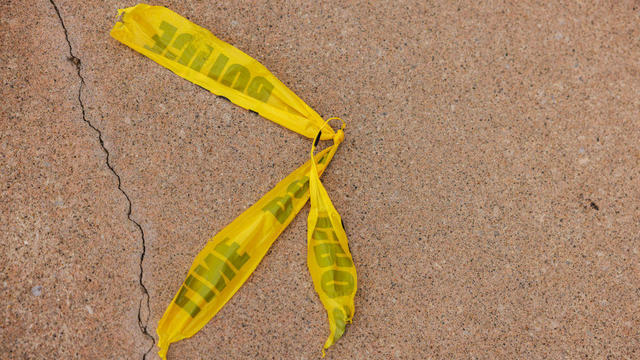 Discarded police tape is left on a sidewalk near the Dick's 
