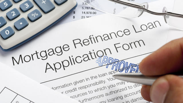 Approved Mortgage Refinance Application Form with pen, calculato 