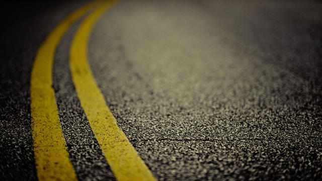Double yellow line on cracked asphalt 