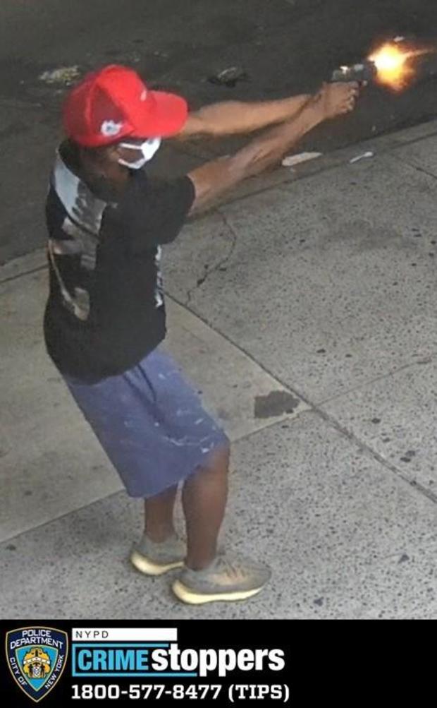 Surveillance photo shows a man firing a gun on a sidewalk. 
