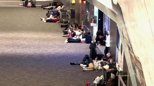 People lay on the floor at LaGuardia Airport. 