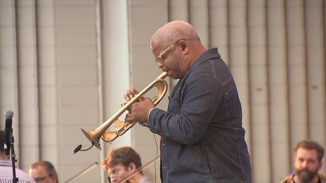 A trumpet player performs on stage. 