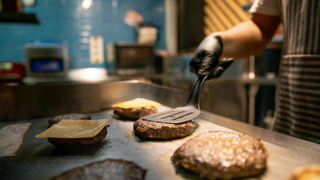 Close-up on a chef preparing burgers at a restaurant 