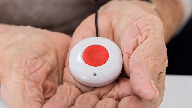 Senior Woman Holding Alarm Button 