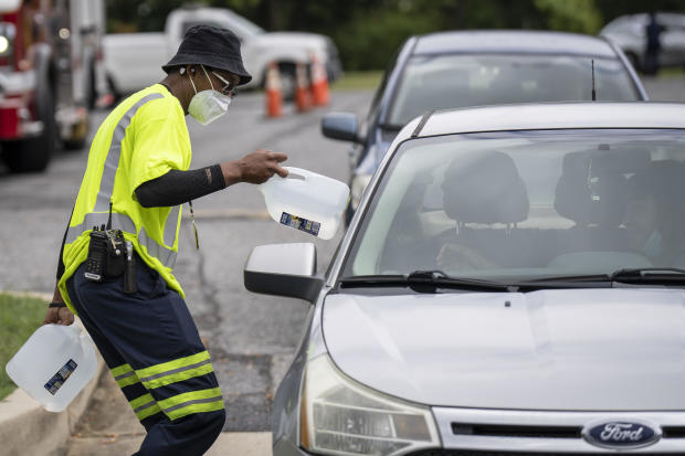 Workers with the Baltimore City Department of Public Works distribute jugs of water to city residents at the Landsdowne Branch of the Baltimore County Library on Sept. 6, 2022, in Baltimore, Maryland. 