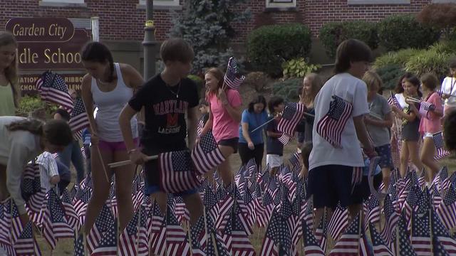 Students at Garden City Middle School plant American flags in the ground to honor the victims of 9/11. 