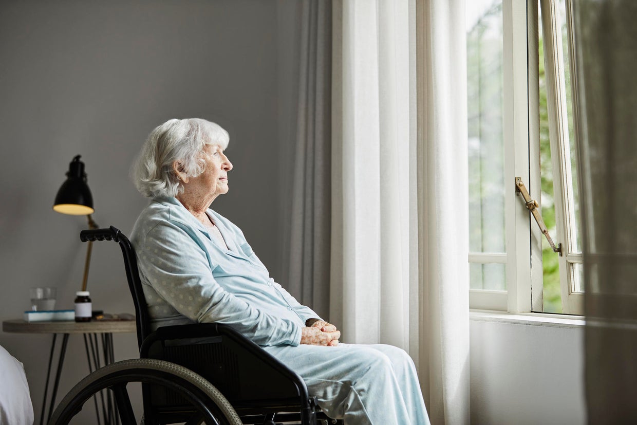 Contemplated senior female sitting on wheelchair 