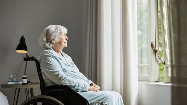 Contemplated senior female sitting on wheelchair 