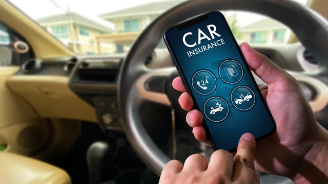 Cropped Hands Of Person Using Mobile Phone In Car 