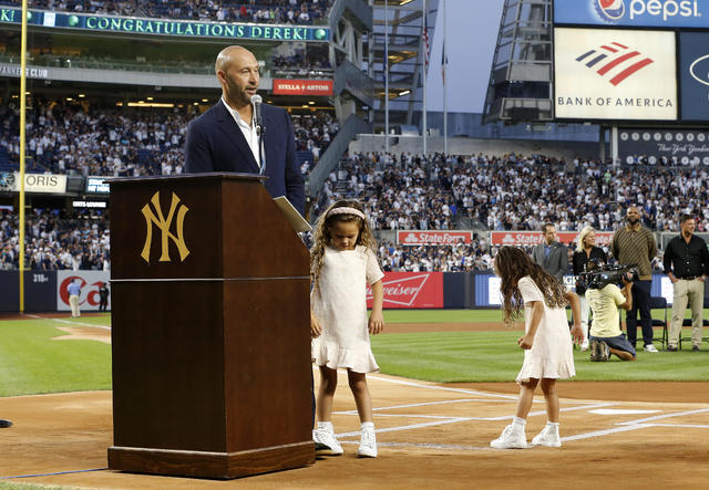 Derek Jeter of the New York Yankees sets down the World Series trophy as  the Yankees are honored and given keys to the city at City Hall following a  ticker tape parade