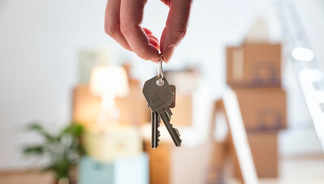 Close-up of woman holding house key in new home