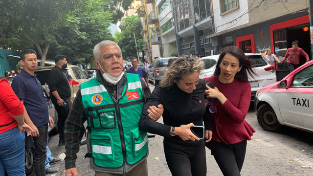 People stand in the street after a quake in Mexico City, Mexico, September 19, 2022. 