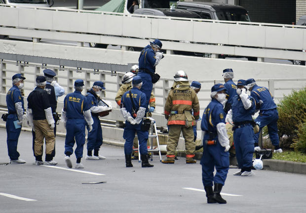 Police officers investigate at the site where a man who was protesting a state funeral for former Japanese Prime Minister Shinzo Abe set himself on fire 