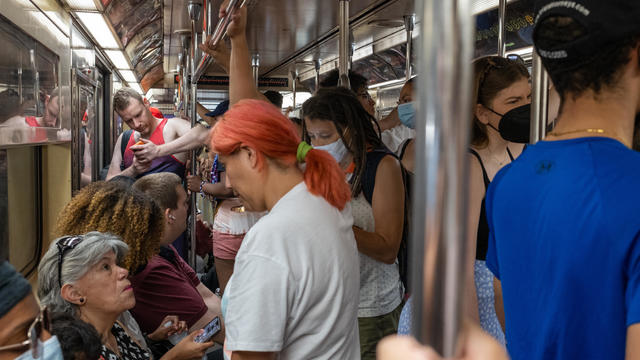 People with and without masks pack onto a non air-conditioned subway car on July 23, 2022 in New York City. 