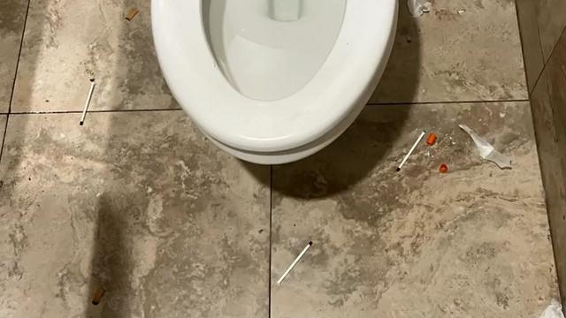 Apparently used needles litter the floor by a toilet inside Glendale's Cooper Rapid Rehousing Center. 