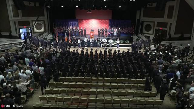 First responders file into an auditorium for a graduation ceremony. 