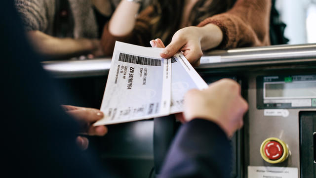 Travellers Getting Boarding Passes At Check-In 