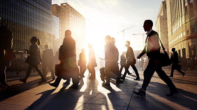 Employees walking to work in the city at sunrise 