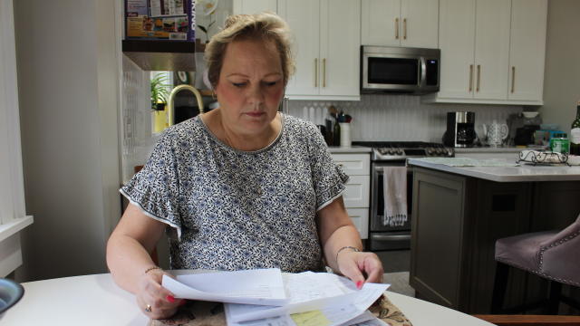 Peggy Dula looks over her medical bills 