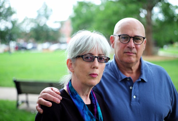White-haired woman and bald man standing in a park