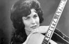Loretta Lynn poses for a portrait holding a guitar that has her name spelled down the fretboard in circa 1961 in Nashville, Tennessee. 