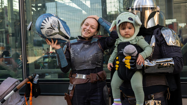 A family dressed as Star Wars' Bo Katan, Mandalorian and Baby Yoda (Grogu) pose outside Comic Con on October 07, 2022 in New York City. 
