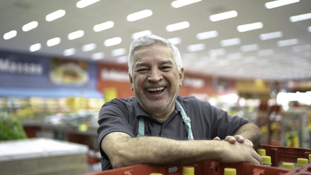 Portrait of smiling senior supermarket employee 