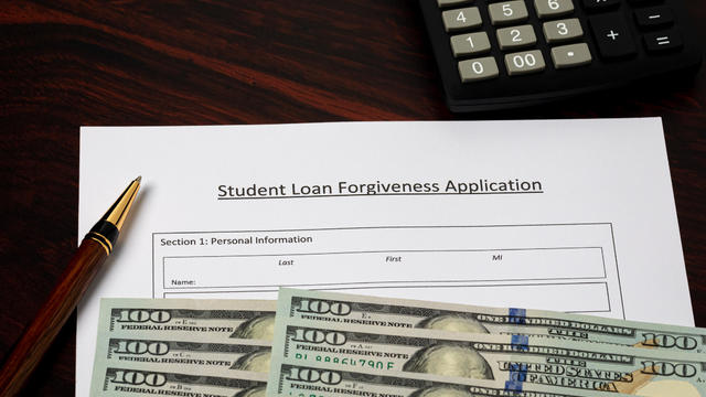 Student loan forgiveness application with cash money. Student debt crisis, tuition assistance and financial aid concept. 