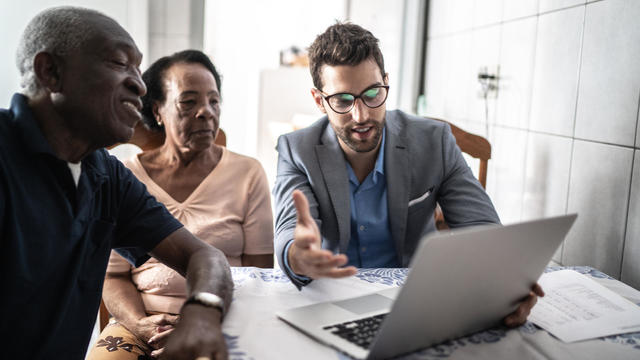 Senior couple having a consultation with a financial advisor at home 