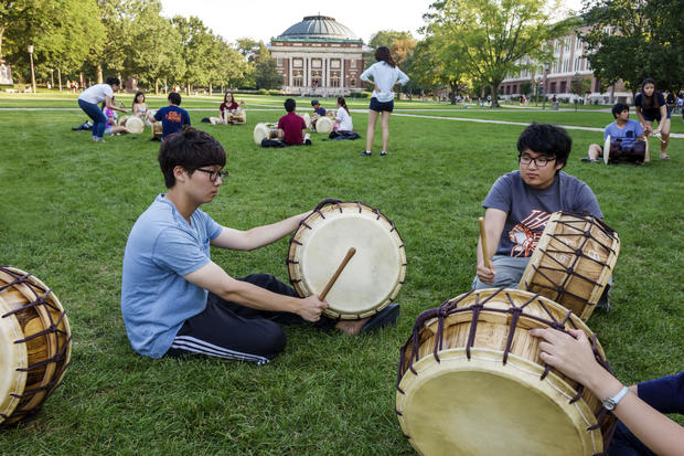 Teen students playing drums on campus of the University of Illinois. 