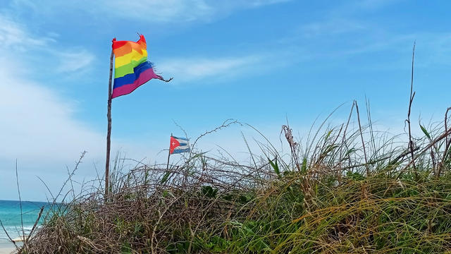 Gay flag and Cuban flag on beach 