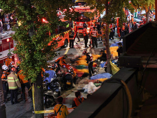 Rescue team and firefighters work on the scene where dozens of people were injured in a stampede during Halloween festival in Seoul 
